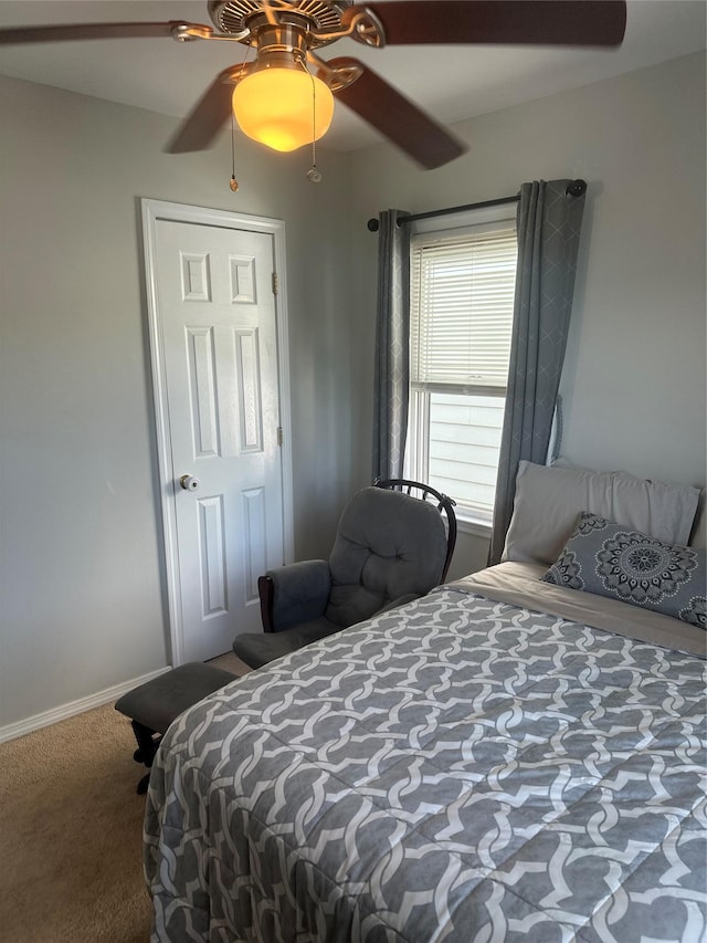 carpeted bedroom featuring baseboards and a ceiling fan