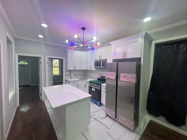 23-21 98th St, Flushing, NY 11369 - kitchen featuring appliances with stainless steel finishes, a chandelier, white cabinets, a sink, and ornamental molding