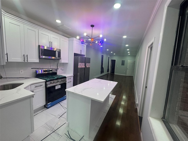 23-21 98th St, Flushing, NY 11369 - kitchen with appliances with stainless steel finishes, ornamental molding, a sink, white cabinetry, and recessed lighting