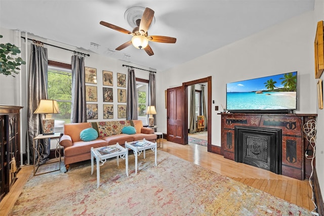 96 E Main St, Port Jervis, NY 12771 - living area featuring wood finished floors, a fireplace, plenty of natural light, and a ceiling fan