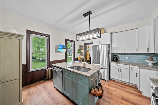96 E Main St, Port Jervis, NY 12771 - kitchen featuring a sink, appliances with stainless steel finishes, white cabinetry, wainscoting, and light wood-type flooring