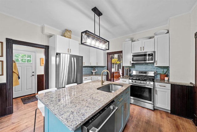 96 E Main St, Port Jervis, NY 12771 - kitchen featuring appliances with stainless steel finishes, a sink, crown molding, white cabinets, and light wood-type flooring