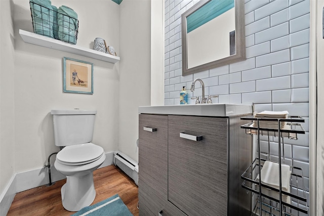 96 E Main St, Port Jervis, NY 12771 - half bath with a baseboard radiator, wood finished floors, toilet, baseboards, and vanity