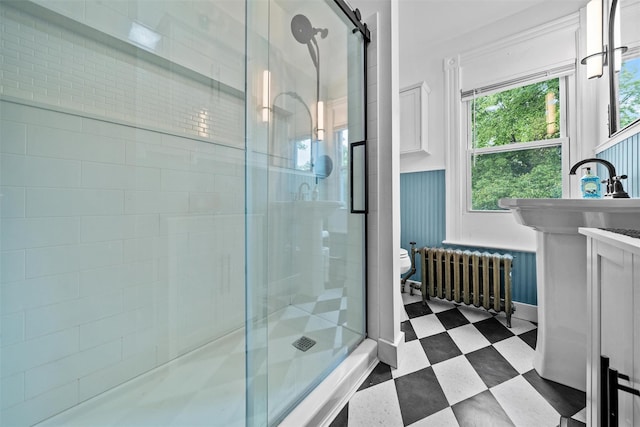 96 E Main St, Port Jervis, NY 12771 - bathroom featuring radiator heating unit, a shower stall, a sink, tile patterned floors, and toilet