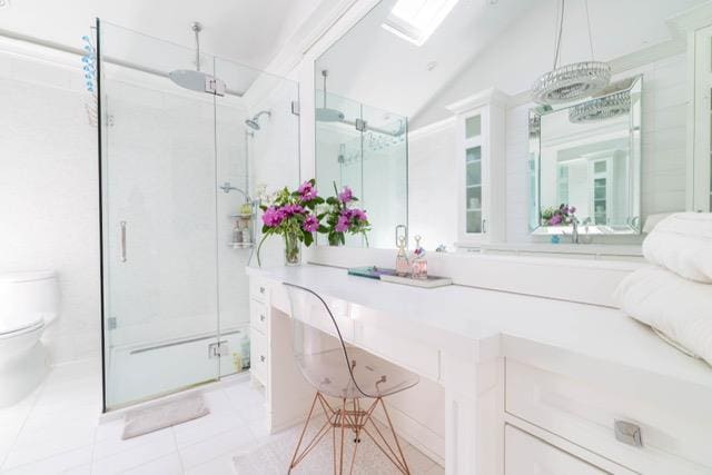 5 Samuel Ct, Syosset, NY 11791 - full bath with toilet, a stall shower, tile patterned flooring, lofted ceiling, and a skylight