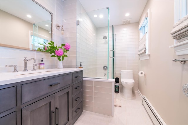 5 Samuel Ct, Syosset, NY 11791 - bathroom featuring vanity, toilet, a baseboard heating unit, tile walls, and tiled shower / bath combo