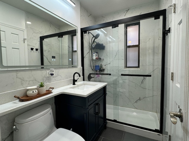 bathroom with toilet, tile patterned floors, vanity, and a marble finish shower