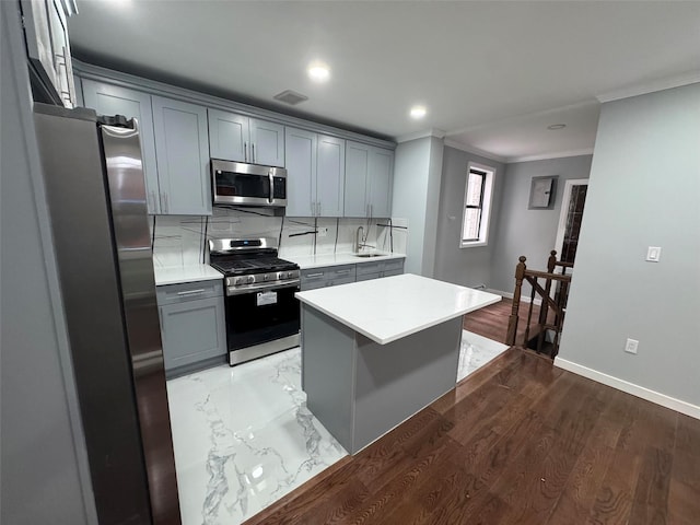 527 E 5th St, Brooklyn, NY 11218 - kitchen with decorative backsplash, gray cabinets, light countertops, ornamental molding, and stainless steel appliances