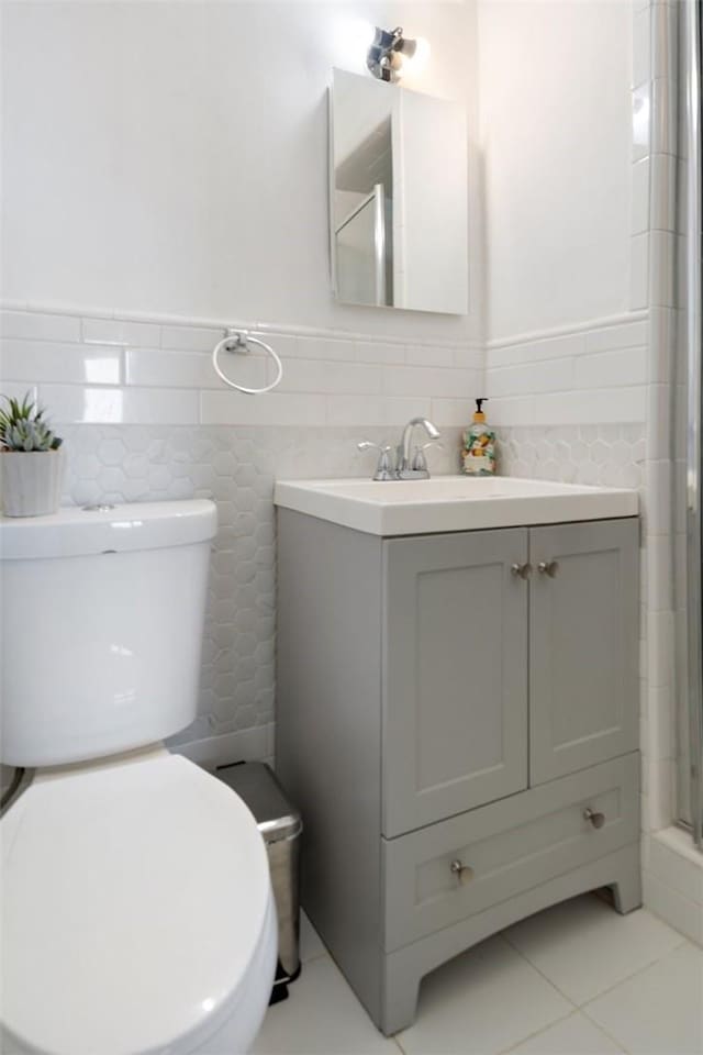 full bath featuring toilet, a shower with door, tile patterned floors, and vanity