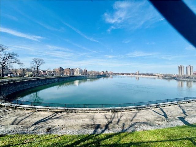 view of pool with a water view and fence