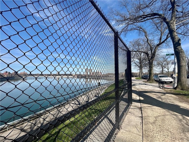 view of property's community with a tennis court and fence