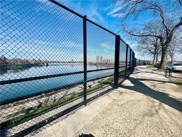 view of property's community featuring a water view and fence