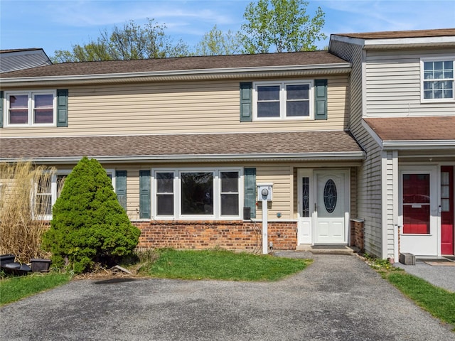 multi unit property with brick siding and roof with shingles