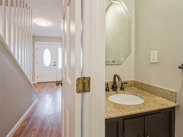 bathroom with vanity, baseboards, and wood finished floors