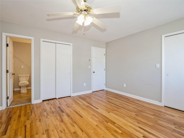 unfurnished bedroom with baseboards, light wood-style floors, ensuite bath, and a ceiling fan