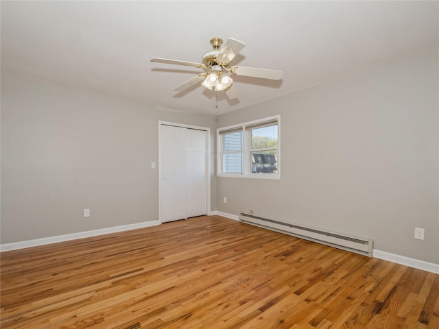 empty room with a ceiling fan, light wood-type flooring, baseboards, and baseboard heating