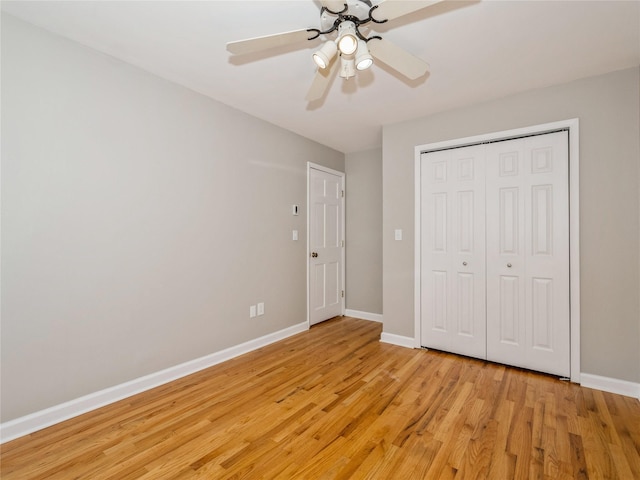 unfurnished bedroom featuring baseboards, a closet, a ceiling fan, and light wood-style floors
