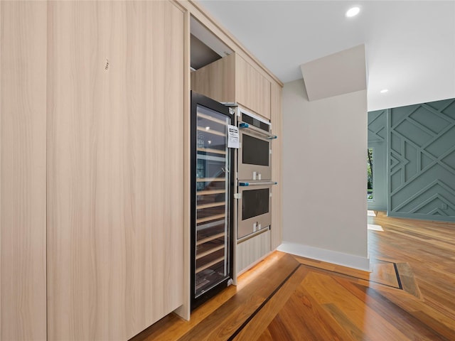5 N Hills Rd, East Norwich, NY 11732 - kitchen with double oven, wine cooler, modern cabinets, light wood-style floors, and light brown cabinetry