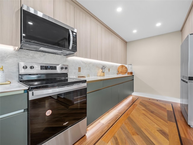 5 N Hills Rd, East Norwich, NY 11732 - kitchen with appliances with stainless steel finishes, modern cabinets, tasteful backsplash, light countertops, and recessed lighting