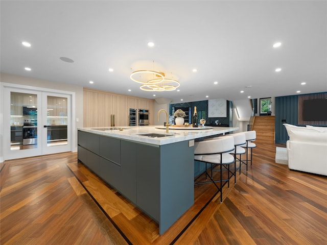 5 N Hills Rd, East Norwich, NY 11732 - kitchen featuring a sink, a large island, modern cabinets, wood finished floors, and recessed lighting