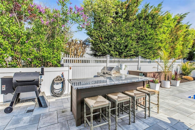 view of patio / terrace with grilling area, fence, and outdoor dry bar