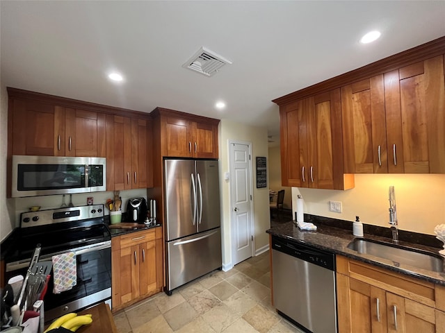 140A Laurance Ln, Ridge, NY 11961 - kitchen featuring appliances with stainless steel finishes, a sink, dark stone countertops, recessed lighting, and brown cabinets