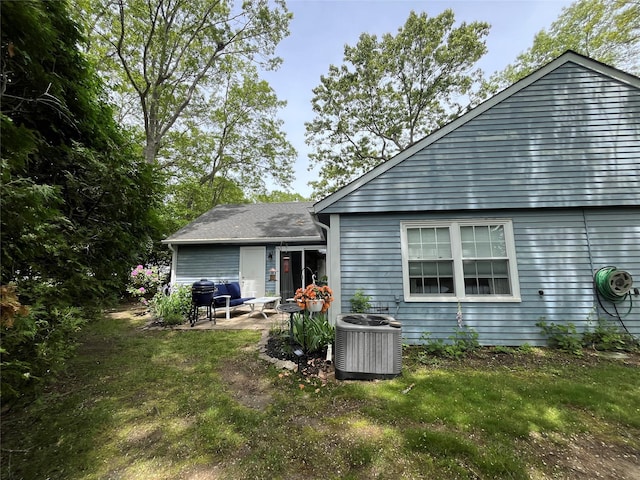 140A Laurance Ln, Ridge, NY 11961 - rear view of property with central air condition unit, a patio, and a lawn