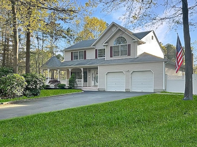 view of front of home featuring a porch, fence, driveway, and a front yard