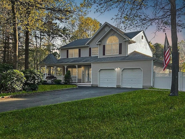 view of front of house featuring a porch, fence, driveway, and a front lawn