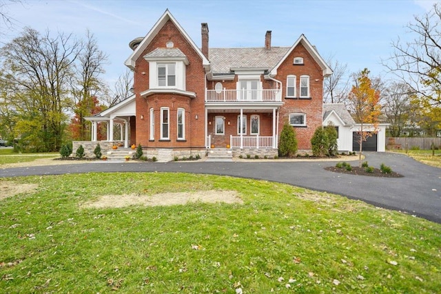 260 Main St, Goshen, NY 10924 - view of front of house with a balcony, a chimney, brick siding, a porch, and a front lawn
