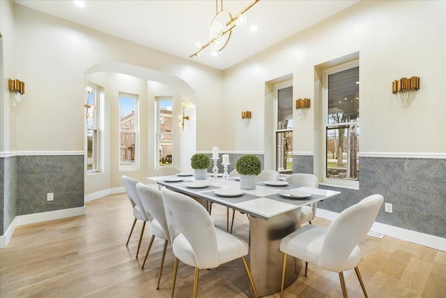 260 Main St, Goshen, NY 10924 - dining space featuring arched walkways, a wealth of natural light, light wood finished floors, and a wainscoted wall