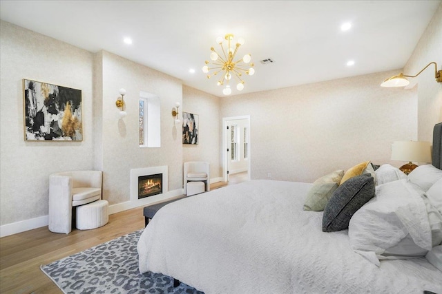 260 Main St, Goshen, NY 10924 - bedroom with a warm lit fireplace, wood finished floors, recessed lighting, a chandelier, and baseboards