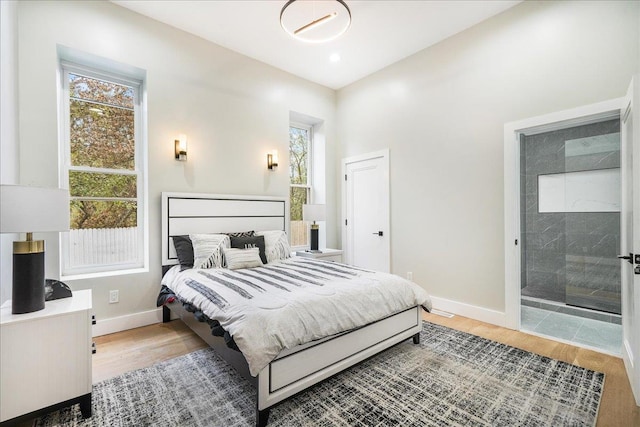 260 Main St, Goshen, NY 10924 - bedroom with baseboards, multiple windows, light wood-style floors, and connected bathroom