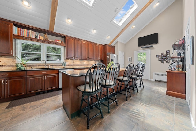 142 Rte 25a, Shoreham, NY 11786 - kitchen with a sink, stainless steel appliances, a skylight, radiator, and a kitchen breakfast bar