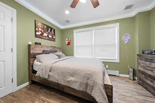 142 Rte 25a, Shoreham, NY 11786 - bedroom featuring a baseboard heating unit, baseboards, wood finished floors, ornamental molding, and recessed lighting