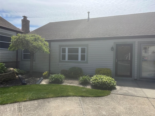 exterior space featuring roof with shingles