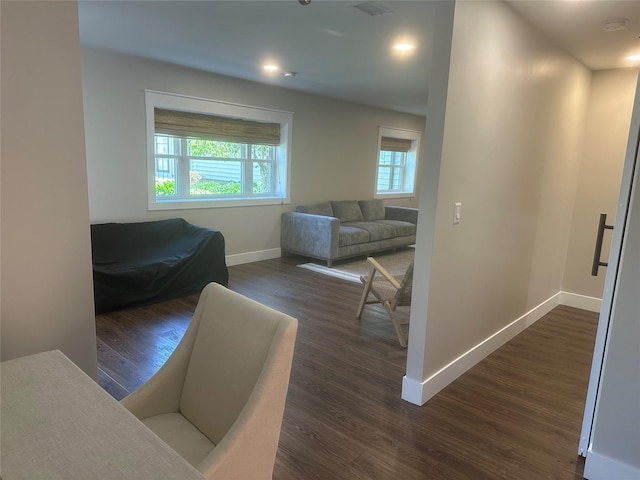 interior space with multiple windows, dark wood-style flooring, and baseboards