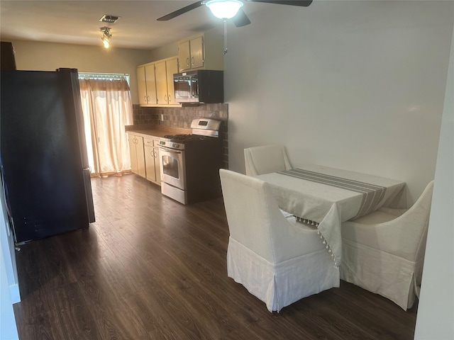 kitchen with freestanding refrigerator, stainless steel gas range, ceiling fan, black microwave, and backsplash
