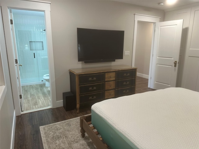 bedroom featuring baseboards, dark wood-style flooring, and ensuite bath