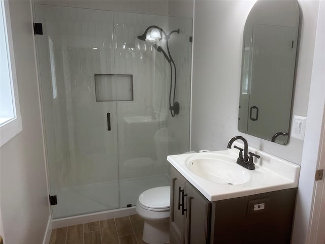 bathroom featuring vanity, toilet, and a stall shower