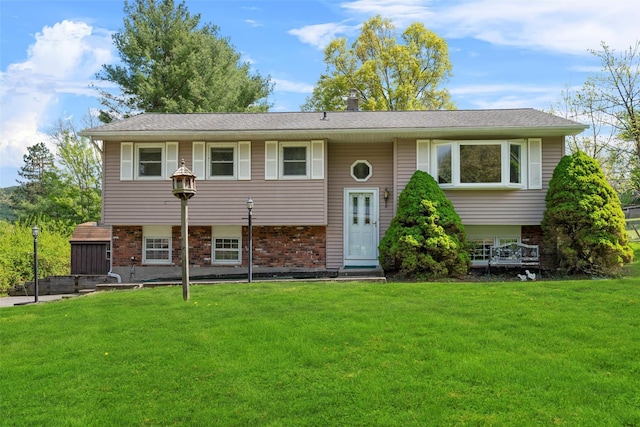 split foyer home featuring a front yard and brick siding