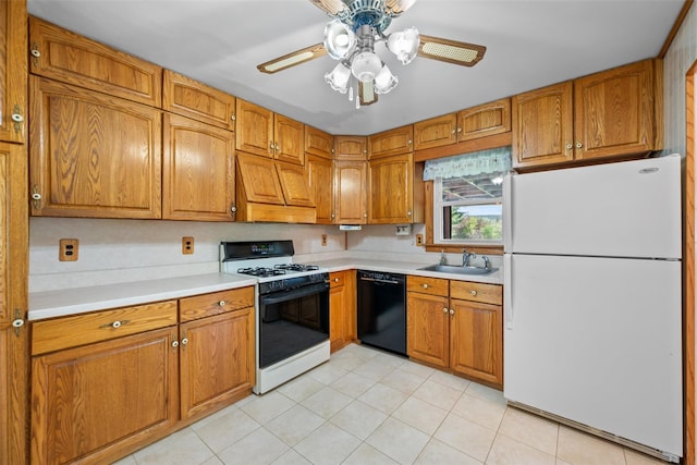 kitchen featuring a sink, freestanding refrigerator, black dishwasher, brown cabinetry, and range with gas stovetop
