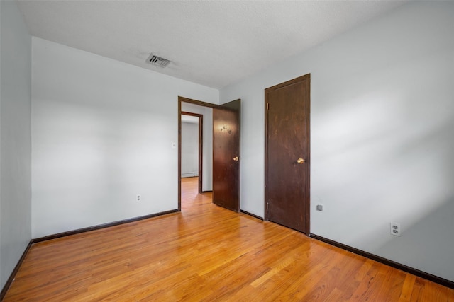 unfurnished bedroom with light wood-style flooring, baseboards, and visible vents