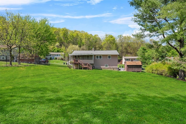 back of house featuring stairs, an outdoor structure, a deck, a storage unit, and a yard