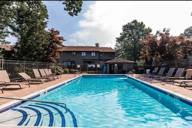 community pool featuring a patio and fence