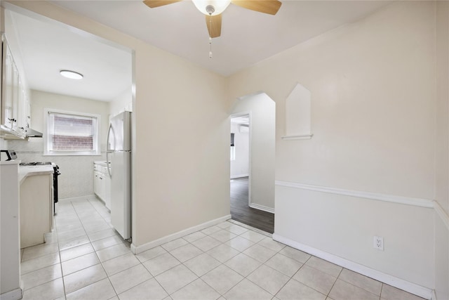 43-28 196th St, Flushing, NY 11358 - spare room with arched walkways, ceiling fan, baseboards, and light tile patterned flooring