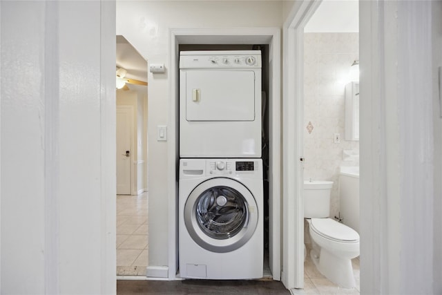 43-28 196th St, Flushing, NY 11358 - bathroom with stacked washing maching and dryer, tile patterned flooring, toilet, and ceiling fan