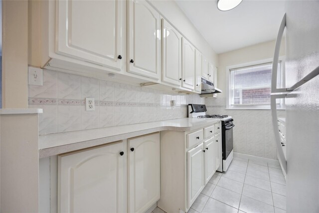 43-28 196th St, Flushing, NY 11358 - kitchen featuring gas range oven, under cabinet range hood, white cabinets, and light countertops