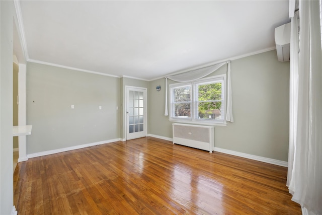43-28 196th St, Flushing, NY 11358 - spare room featuring radiator heating unit, baseboards, ornamental molding, and wood finished floors