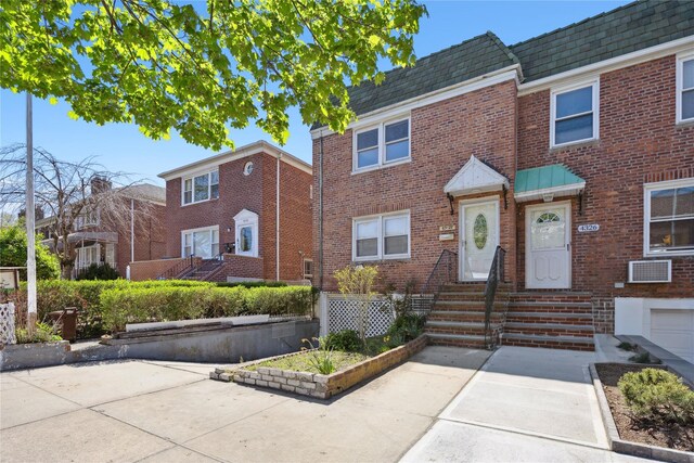 43-28 196th St, Flushing, NY 11358 - view of property featuring entry steps, mansard roof, roof with shingles, and brick siding